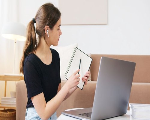 Person preparing notes on a desk before an online educational webinar
